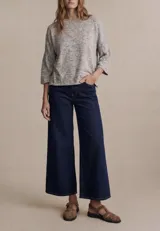 Sweater de punto con efecto jaspeado, de corte oversize, cuello redondo y mangas largas con terminación acampanada tipo volado.