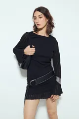 Vestido corto de manga larga acampanada, color marrón óxido, con textura acanalada y terminación ondulada en el ruedo.