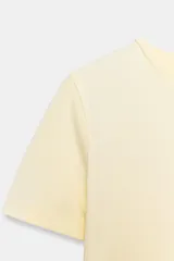Camiseta corta de color amarillo pastel, con cuello redondo y mangas cortas de ajuste slim.