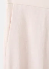 Pantalón de vestir de lino color beige, de corte recto y tiro medio, con trabillas, bolsillos laterales y bolsillos posteriores de ribete.