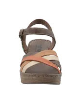 Sandalias de cuero RKF modelo Dalia, con tacón ancho efecto corcho y plataforma. Posee tiras cruzadas en la parte delantera en tonos marrón, terracota, tostado y beige, y tira al tobillo con hebilla metálica.