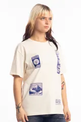 Remera unisex de corte holgado en color beige, con estampado gráfico en azul que incluye motivos japoneses y texto.
