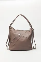 Cartera convertible en mochila, confeccionada en cuero sintético texturizado color marrón. Presenta un diseño con recortes, bolsillo frontal con cierre diagonal, herrajes metálicos plateados, asa superior y correas regulables.