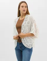 Cardigan abierto estilo kimono, color crudo, con mangas amplias al codo. Presenta una base con textura y motivos florales bordados a tono, con paneles de encaje calado estilo macramé en el frente, puños y ruedo.