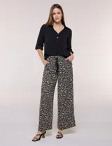 Blusa verde de calce holgado y caída fluida, confeccionada en tejido tipo crepé. Cuenta con cuello camisero con solapa, escote en V y cierre parcial al frente con tres botones metálicos. Las mangas son largas con puños abotonados.