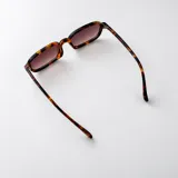 Lentes de sol con armazón rectangular de acetato color beige claro y cristales marrones con protección UV400.