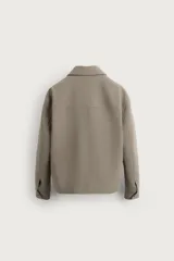 Sobrecamisa boxy fit de tejido compacto color negro, con cuello solapa, manga larga con puño abotonado, bolsillos laterales en costura y cierre frontal de botonadura.