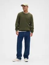 Sweater de punto acanalado en color verde oliva, con cuello redondo y mangas largas. Presenta un diseño de corte holgado y textura acanalada vertical.