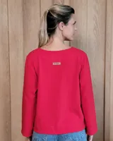 Remera de manga larga color blanco, con cuello redondo y dos bolsillos frontales tipo parche. Presenta un corte recto y holgado con un diseño minimalista.