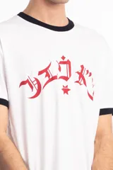 Remera ringer blanca con cuello y bordes de mangas en color negro. Presenta un estampado frontal en color rojo con caracteres estilizados y una estrella central.