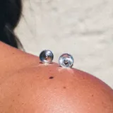 Aros tipo botón de plata 925 con una pequeña esfera en el centro.