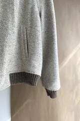 Campera estilo bomber color beige con textura, cierre delantero, cuello, puños y ruedo tejidos. Forrada, confeccionada en lana fina sin teñir.