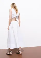 Falda larga blanca de tiro medio y diseño evasé, con cintura elástica y bolsillos laterales.