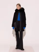 Parka negra de paño con detalles en nylon mate y capucha desmontable con borde de piel de zorro al tono.
