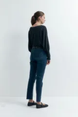 Jean slim de tiro alto color azul oscuro, con corte ajustado desde la cadera hasta el tobillo y largo hasta el tobillo.