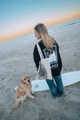 Buzo negro de manga larga con estampa en la espalda con una foto en blanco y negro de una ola y el logo de la marca Glassy.