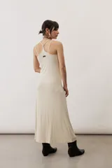 Vestido largo color verde suave, sin mangas, con escote redondo y silueta al cuerpo que se ensancha levemente hacia el dobladillo.