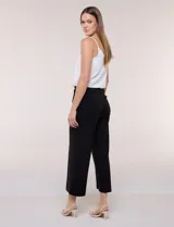 Pantalón crop blanco de corte recto con cintura ancha y botones decorativos laterales. Cuenta con bolsillos y pinzas frontales.