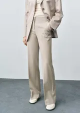 Pantalon de vestir de tiro medio con corte flare, diseño largo y bolsillos laterales. Cuenta con cierre de cremallera, botón y ganchos ocultos.