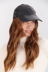 Gorra tipo visera de cuero negro con hebilla plateada en el lateral.