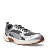 Championes Puma Milenio Tech Light de estilo retro inspirados en los años 2000, con diseño en tonos plateado y gris, detalles de malla transpirable, suela color crema y suela exterior de goma marrón.