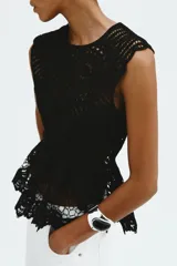Top negro sin mangas de punto estilo crochet, con cuello redondo, cierre oculto en la espalda y diseño de peplum acampanado con ribetes festoneados.