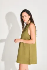 Vestido corto de gabardina color verde oliva, con escote cerrado y silueta amplia.