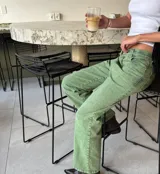 Pantalón jean verde de corte recto y tiro medio, con bolsillos delanteros y traseros.