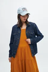 Campera de jean azul oscuro, de corte clásico, con cuello camisero, cierre frontal con botones metálicos, bolsillos con solapa abotonada en el pecho y bolsillos laterales.