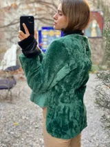 Saco de silueta recta y levemente corto, color verde oscuro. Cuenta con cuello a la base, manga larga y bolsillos laterales discretos.