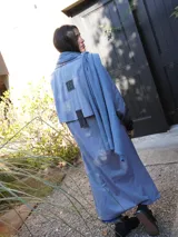 Impermeable color beige con cuello clásico, cierre con botones y cinturón. Detalles en tweed en puños y solapa.