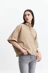 Camisa color beige de manga corta con cuello clásico y corte oversize.