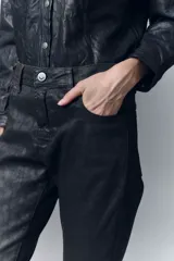 Pantalón de jean con calce skinny y tiro alto, confeccionado en denim negro con un proceso de coating marrón que le otorga una apariencia similar al cuero y un diseño de animal print realizado con láser.