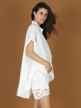 Camisa blanca de mangas cortas con corazones aplicados.