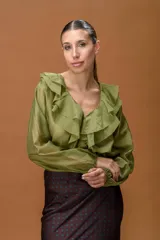 Camisa de color verde oliva con volados en el escote en V y mangas largas con puños elásticos.