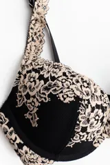 Soutien super push-up negro con detalles de encaje en tono beige en las copas y los breteles. Cuenta con aros, relleno y tirantes ajustables.