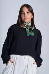 Blusa negra de mangas largas abullonadas y cuello redondo.