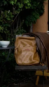 Mochila de cuero genuino con diseño minimalista, compartimento principal amplio con espacio para notebook, bolsillo interno con cierre y bolsillo frontal de acceso rápido. Incluye correas regulables.