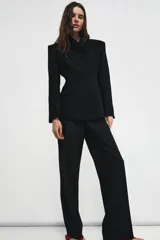Pantalón de vestir de tiro bajo con corte recto, cintura con trabillas, bolsillos laterales y detalle de raya planchada. Cierre frontal con cremallera, botón y ganchos metálicos.