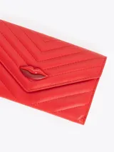 Maxi billetera color negro confeccionada en cuero vacuno, con diseño acolchado de costuras en chevron, solapa frontal y aplique metálico en forma de labios en el centro.