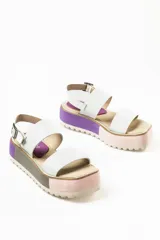 Sandalias negras de cuero con plataforma blanca y hebilla metálica.