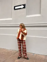 Campera de corderito con diseño de rayas verticales en colores marrón y crema, con cierre frontal y detalles de ribete en color rojo.