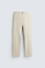Pantalón chino de corte slim fit, confeccionado en tejido elástico. Presenta bolsillos frontales, bolsillos traseros de vivo con botón y cierre frontal con cremallera y botón.