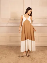 Vestido largo sin mangas, con escote en V y diseño de bloques de color. La parte superior es blanca, la sección media es color camel/marrón claro, y el ruedo inferior es blanco.