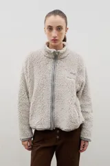 Campera de sherpa color beige con cuello alto, cierre frontal completo y bordado a contra tono en el pecho.