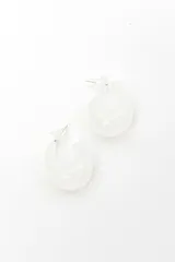 Aros tipo argolla gruesa y abombada, de color blanco y acabado brillante.
