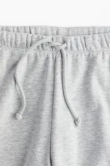 Pantalón jogger amplio en felpa gris melange, con cintura elástica y cordón ajustable, de corte holgado y piernas rectas.