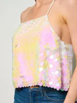 Top corto de tirantes finos cubierto completamente por lentejuelas iridiscentes en tonos pastel. Presenta un diseño cuadrado y holgado con acabado brillante.
