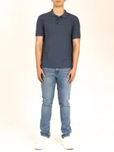 Polo de piqué color azul oscuro jaspeado, manga corta, con cuello y tapeta de tres botones al tono.