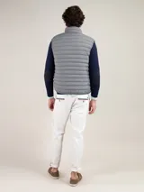 Chaleco gris acolchado para hombre, confeccionado en nylon reciclado repelente al agua, con cierre de cremallera, sisa elástica y logo engomado en el pecho.